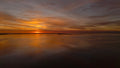 Sunset over a calm body of water with orange and purple hues. Print by Lisa Lake Photography.