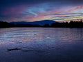 Frozen lake with a branch on the ice at sunset with purple and blue hues. Photography print by Lisa Lake Photography.