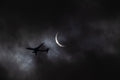Silhouette of an airplane flying against a dark sky with a solar eclipse. Photography print by Lisa Lake Photography.