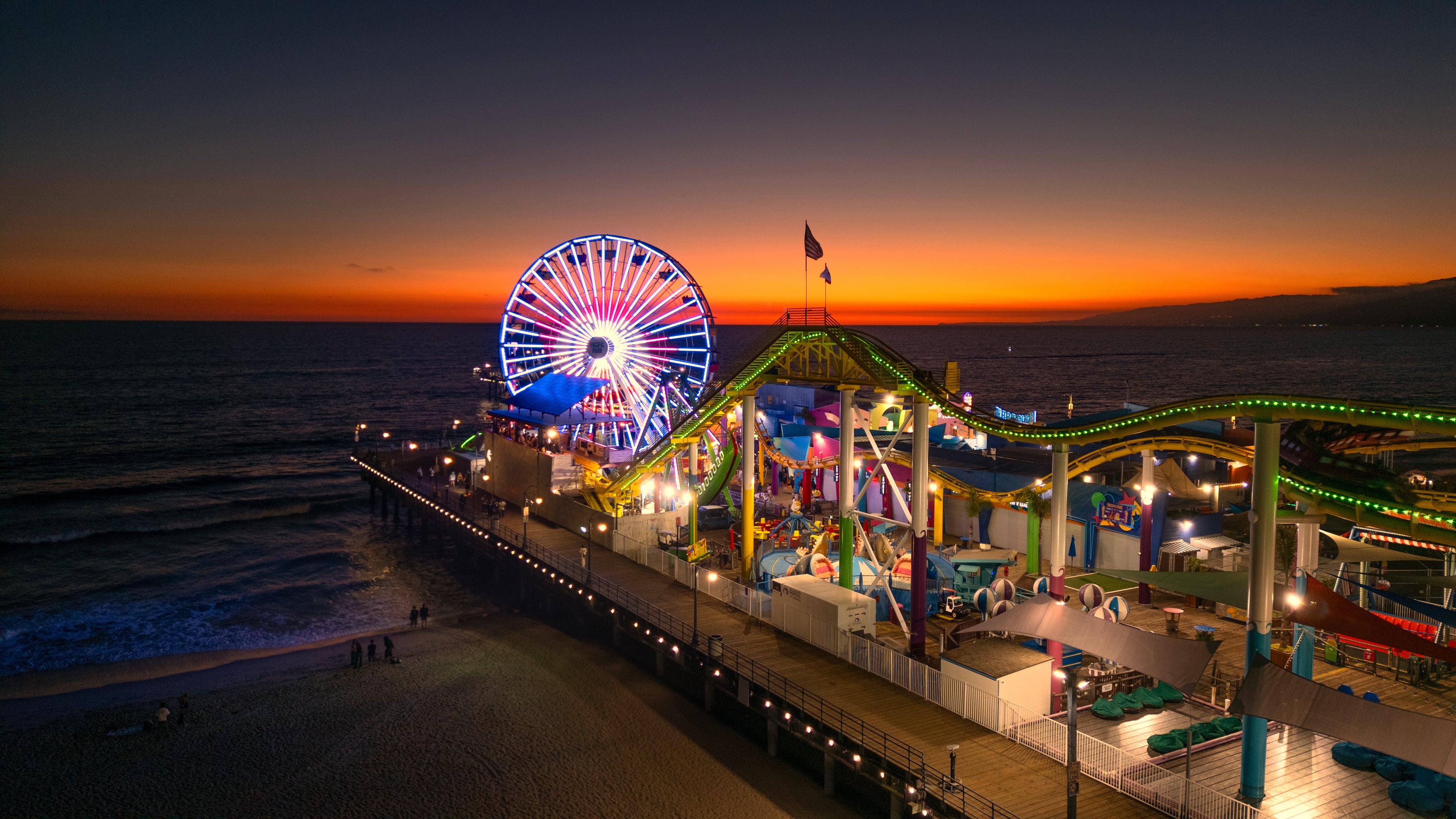 Ferris wheel and roller coaster at a beach amusement park during sunset. Print by Lisa Lake Photography.