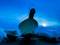 Two boats docked at a marina under a blue sky with a bright light source. Print by Lisa Lake Photography.