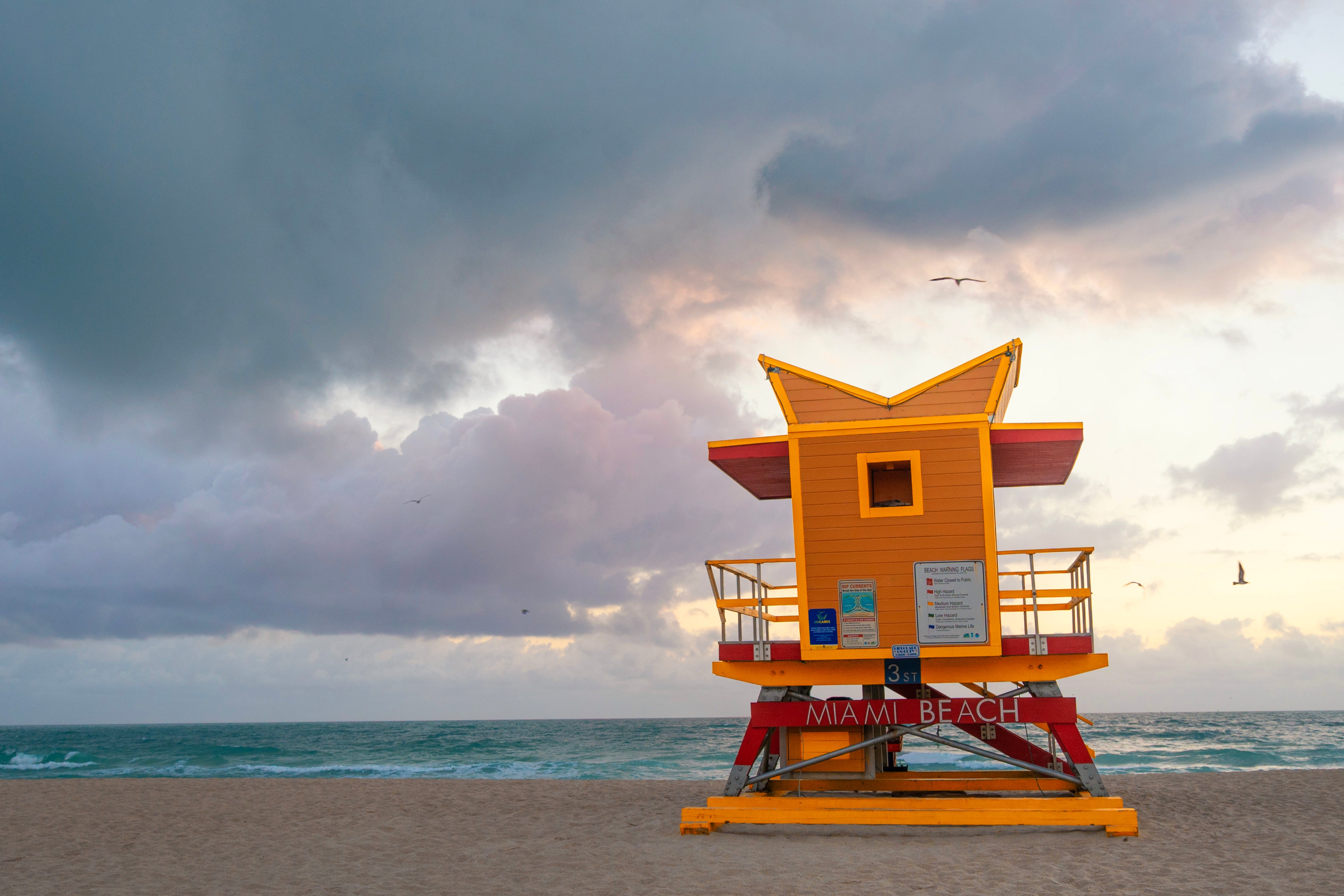 Yellow lifeguard tower at Miami beach with a stormy sky. Print by Lisa Lake Photography.